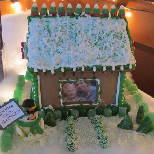 Gingerbread house with a picture of two people on a snowy scene