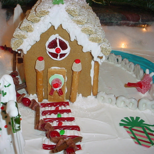 Gingerbread house decorated with candy on a snowy landscape