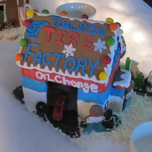Gingerbread house decorated to look like a tire factory with colorful details.