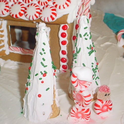 Gingerbread house with candy decorations on a white surface