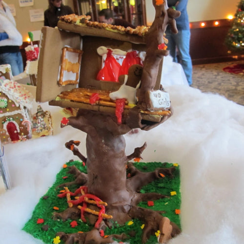 Gingerbread house with a treehouse design on a snowy background