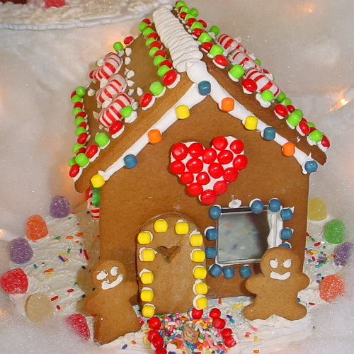 Decorative gingerbread house with colorful candies on a white background