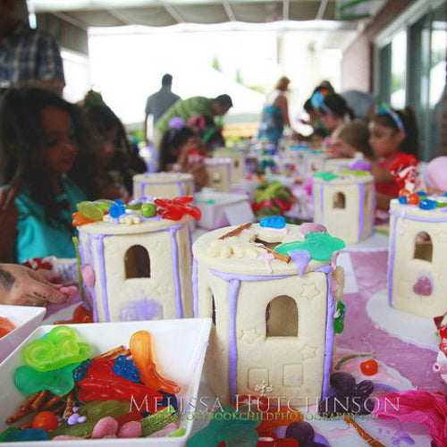 Children's play area with sandcastle structures and toys, featuring Melissa Hutchinson branding.