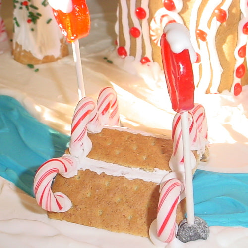 Gingerbread house with candy cane decorations on a white background