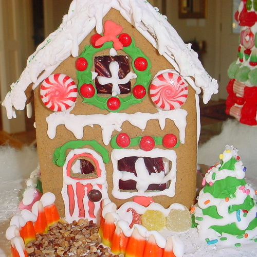 Decorative gingerbread house with candy decorations on a snowy background