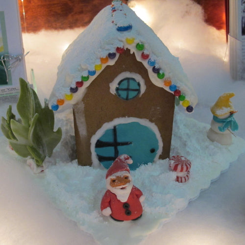 Gingerbread house with decorative elements on a white surface