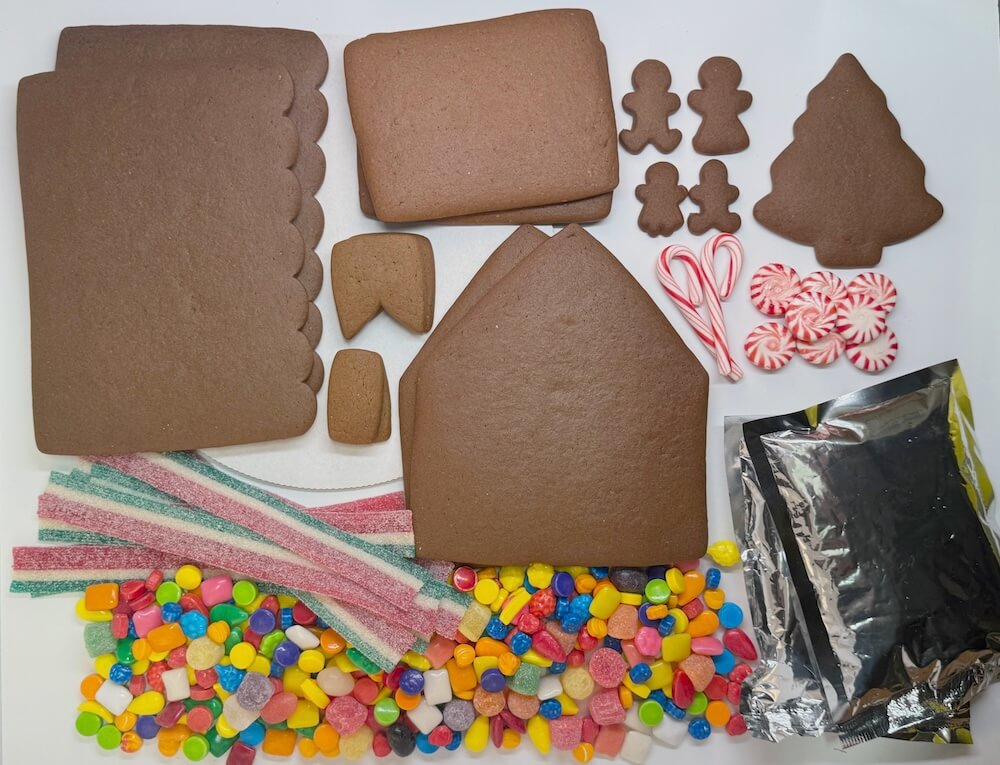 Gingerbread house kit with gingerbread people, candy, on a white background