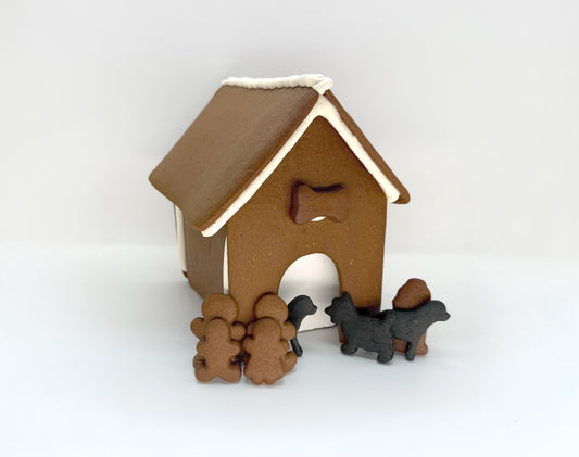 Gingerbread dog house with gingerbread people and dogs on a white background