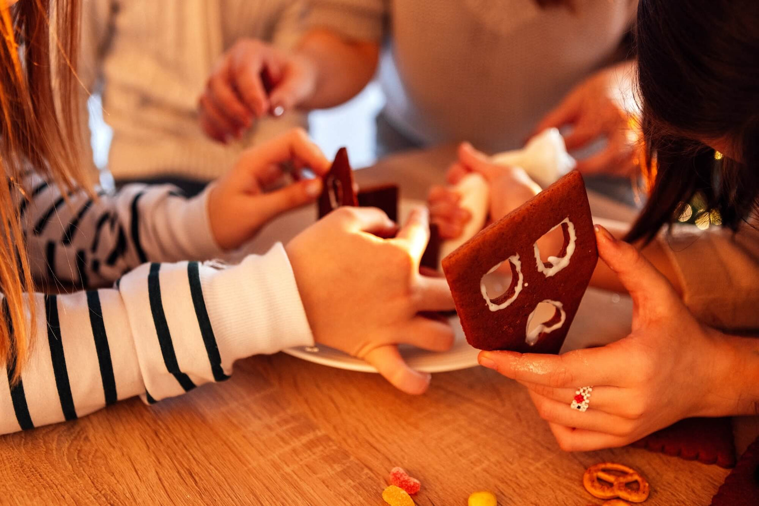 People making gingerbread houses at a table