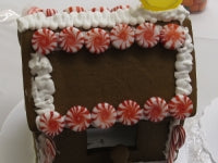 Gingerbread house with decorative flowers on a white background