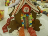Gingerbread house with candy decorations on a table with other items.