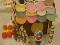 Gingerbread house with colorful decorations on a white background