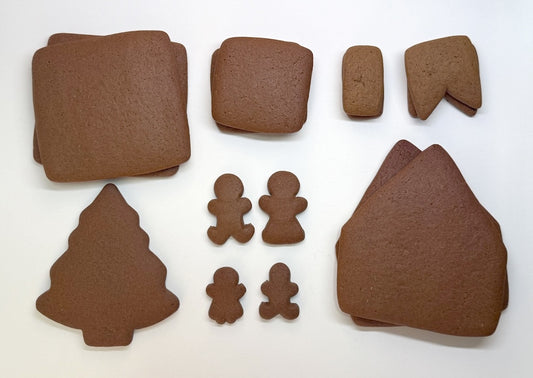 Set of brown gingerbread house and people pieces on a white background