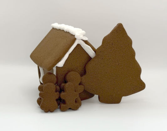 Gingerbread house and tree-shaped cookies on a white background