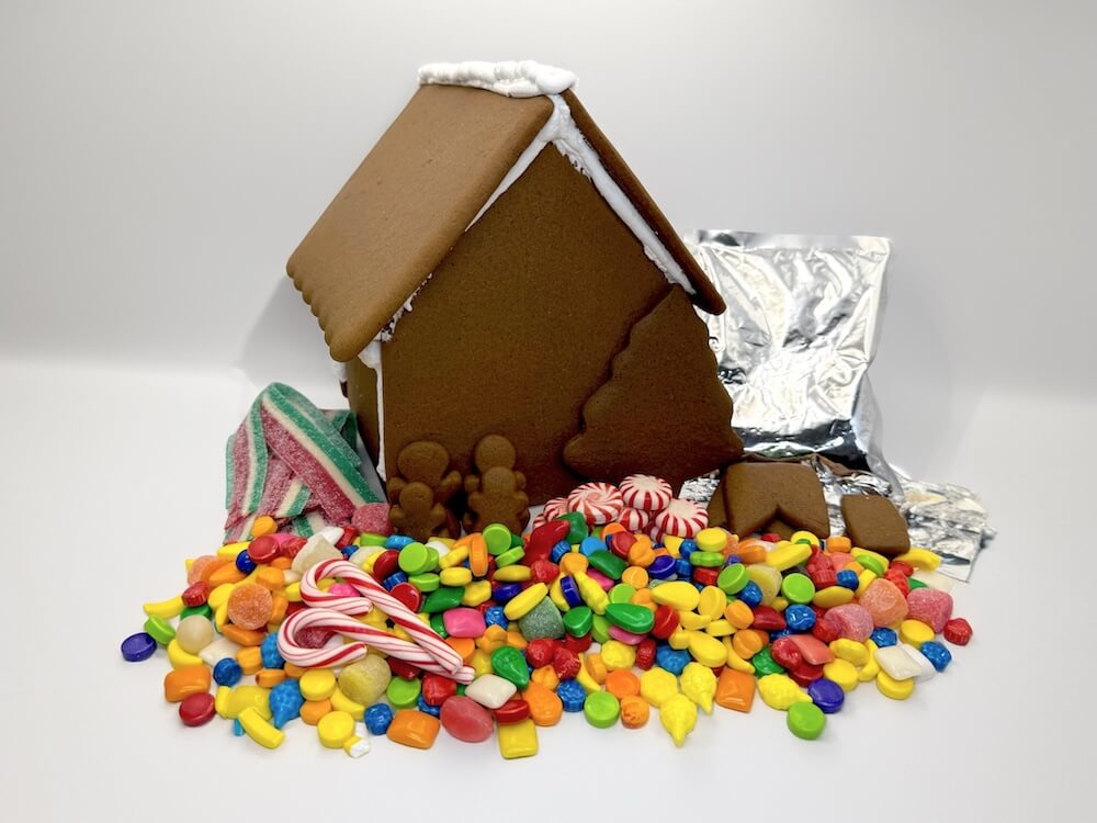 Gingerbread house with colorful candies on a white background