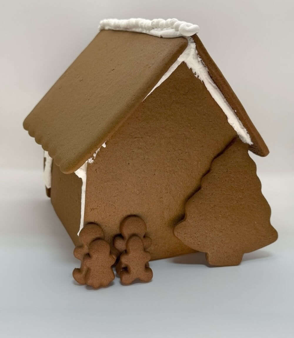 Gingerbread house with gingerbread people on a white background