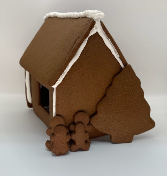 Gingerbread house with a white roof on a light gray background